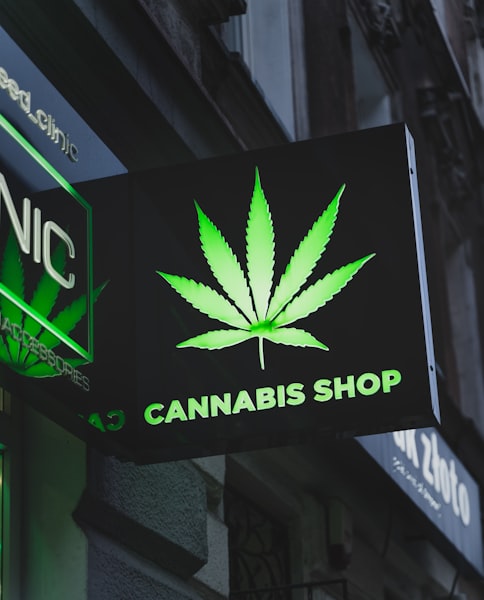 Cannabis shop sign hanging from the side of a European building