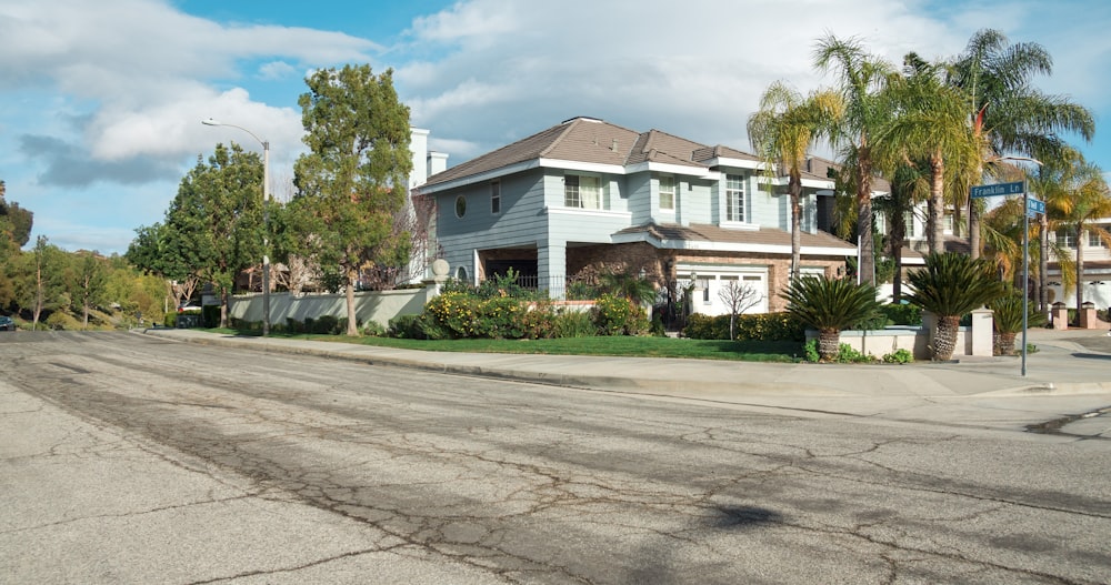 white and brown concrete house near green trees during daytime