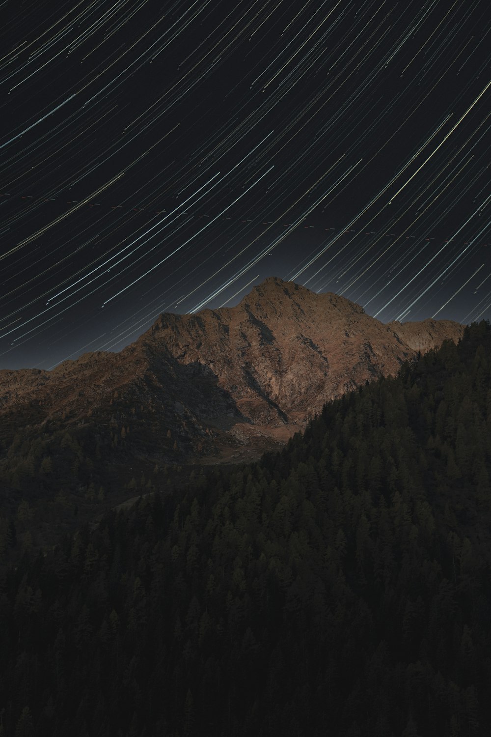 time lapse photography of stars in sky over brown mountains