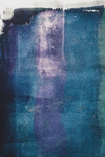 An intricate mixed-media artwork blending textures and deep blue hues.