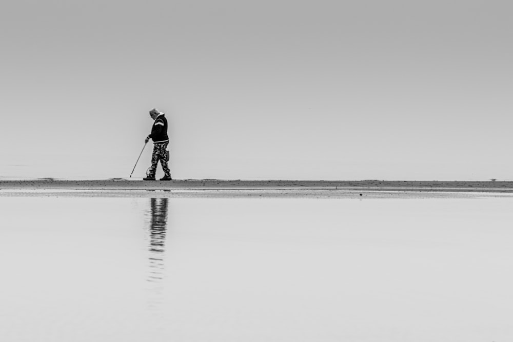 man in black jacket walking on the beach