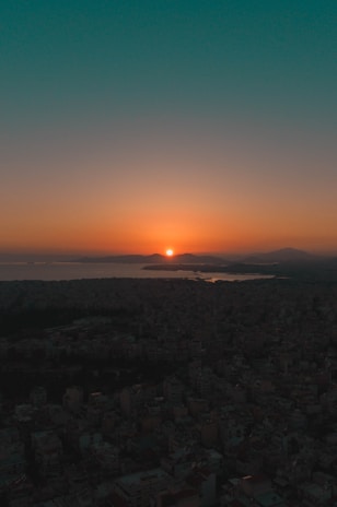 A scenic sunset over a landmark cityscape with glowing lights.