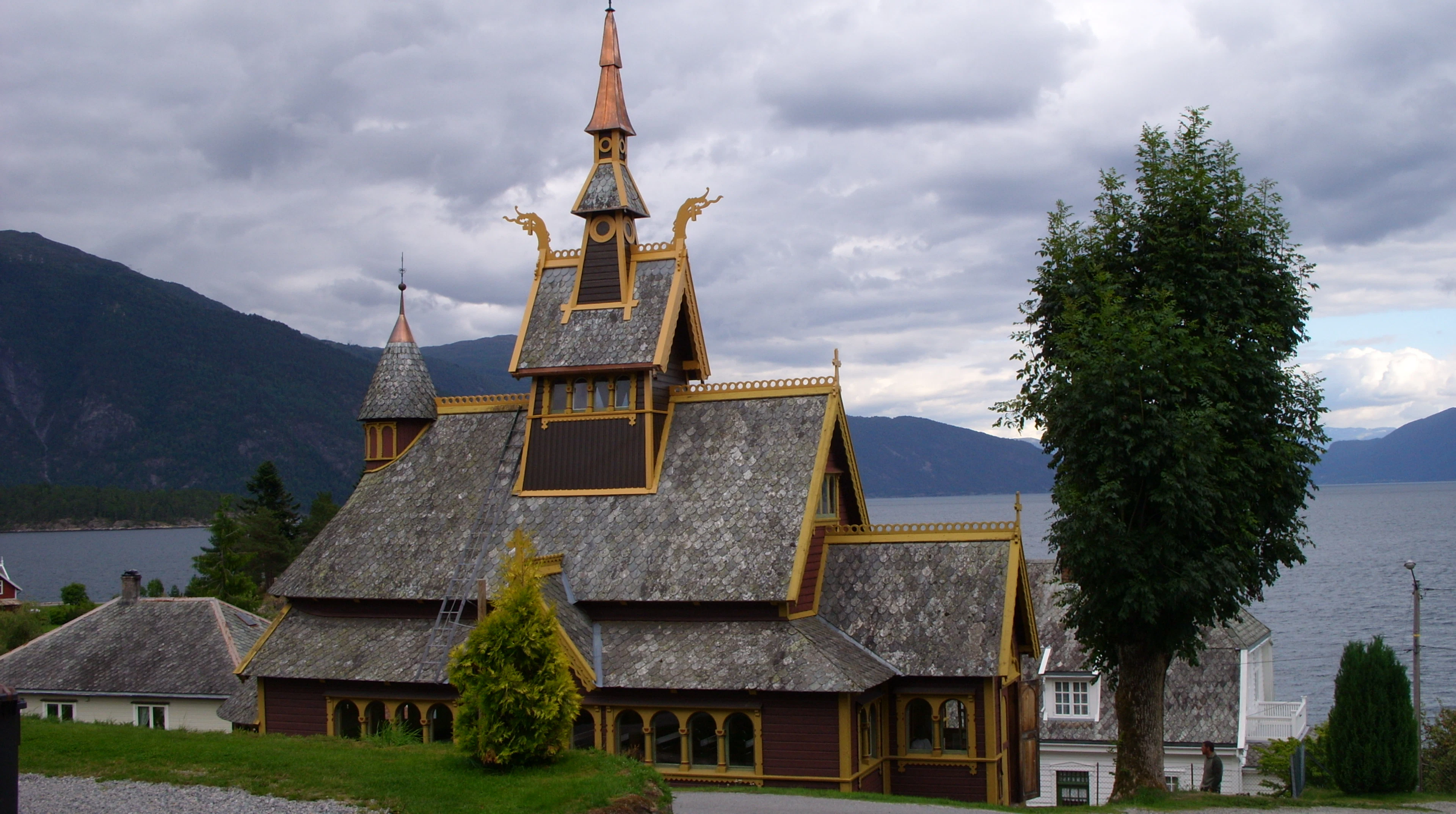 The wooden St Olaf's Church in Balestrand, with the Sognefjord behind