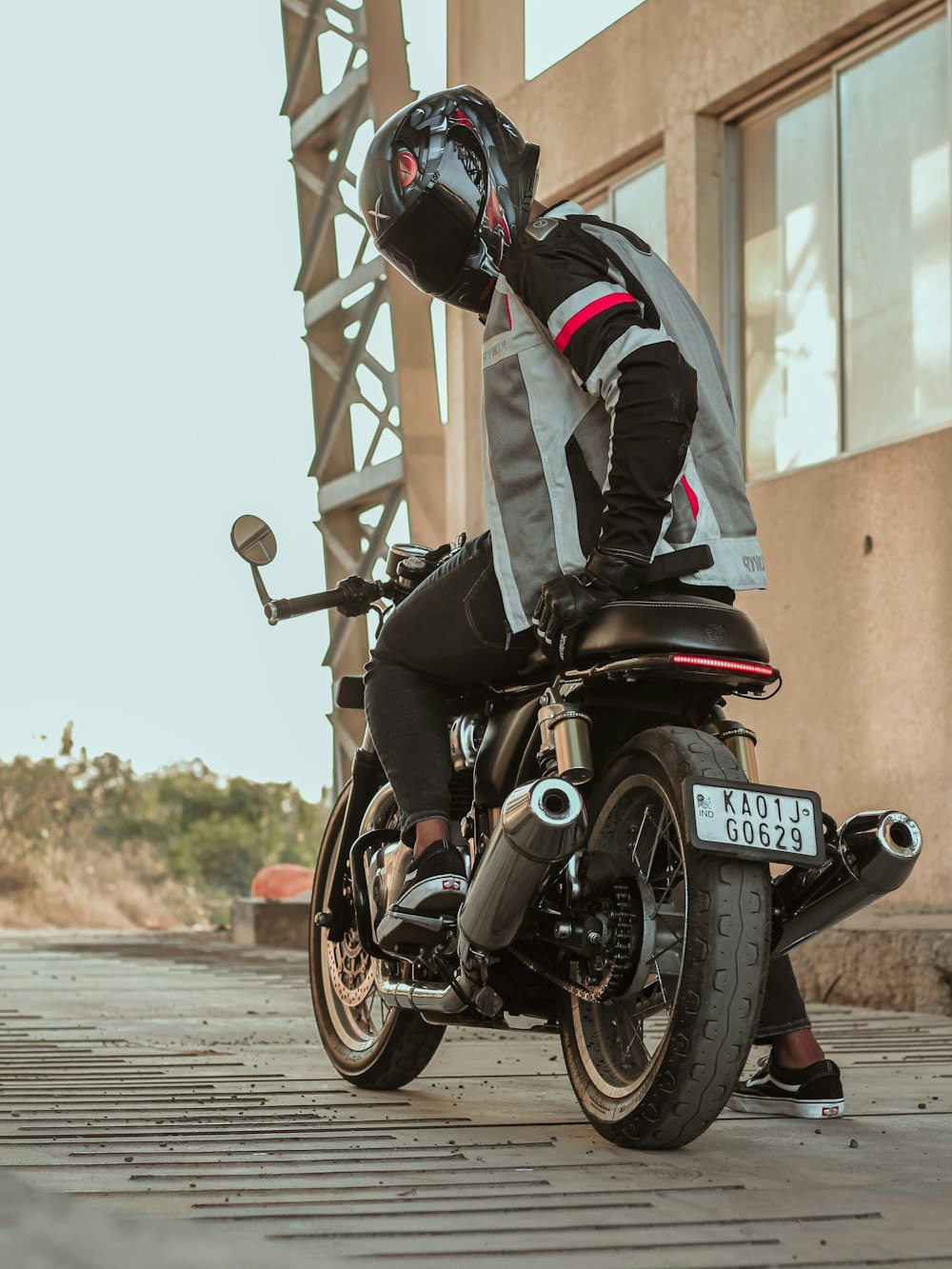 uomo in tuta da motociclista nera e rossa in sella a una moto sportiva nera e rossa durante il giorno