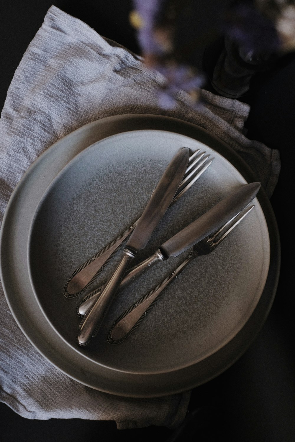 stainless steel fork and bread knife on round plate