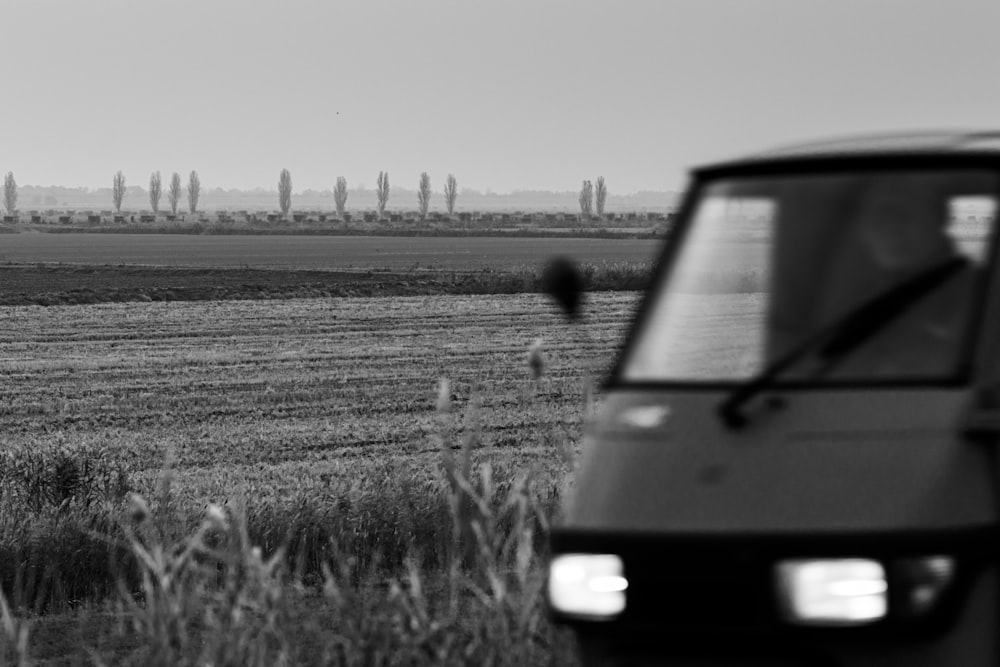 grayscale photo of van on grass field