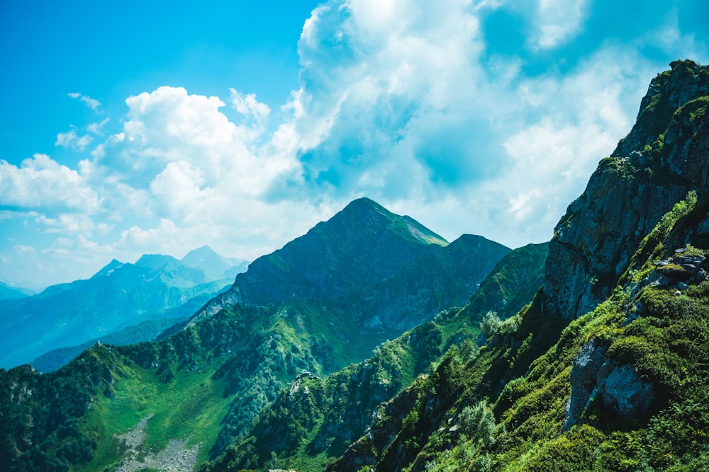 green mountains under white clouds and blue sky during daytime