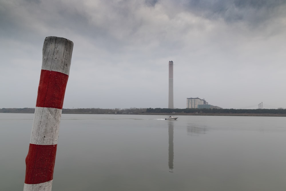 red and white tower near body of water