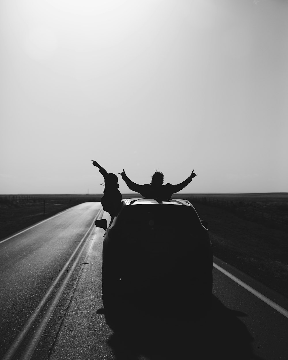 Foto en escala de grises de un hombre montando en motocicleta en la carretera