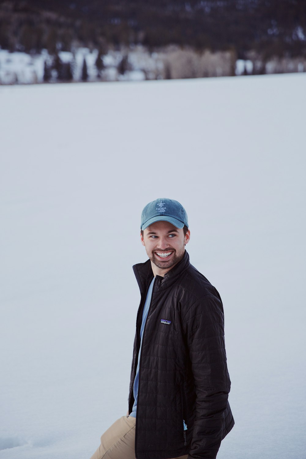 man in black jacket wearing blue knit cap