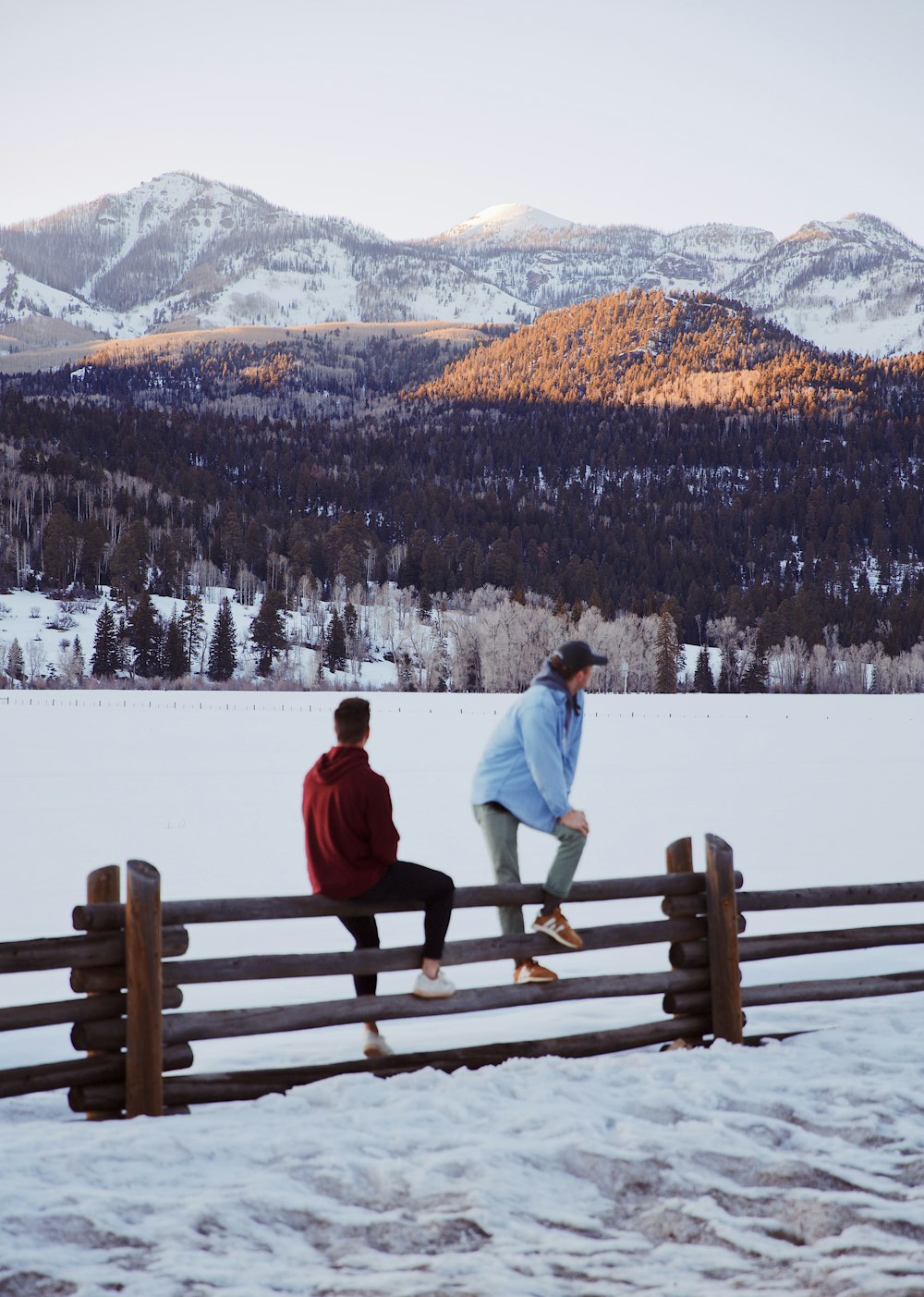 man in white jacket and black pants standing on snow covered field during daytime