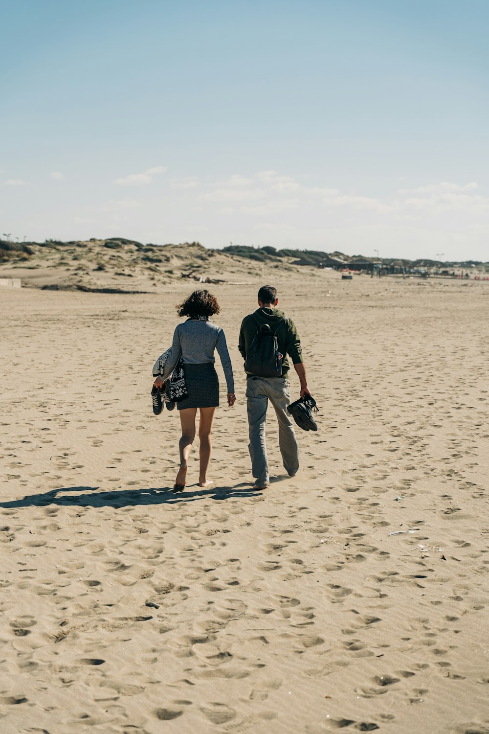 Mann und Frau gehen tagsüber auf Sand