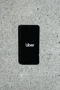Smartphone displaying the uai mobi app with a local city taxi nearby.
