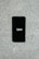 A smartphone displaying the Uber logo is placed on a concrete surface. The phone screen is black with the white Uber logo in the center.