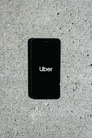 Smartphone displaying the uai mobi app with a local city taxi nearby.