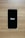 A smartphone with a black screen displays the Uber logo in white text. The phone is placed on a wooden surface with a light brown texture.