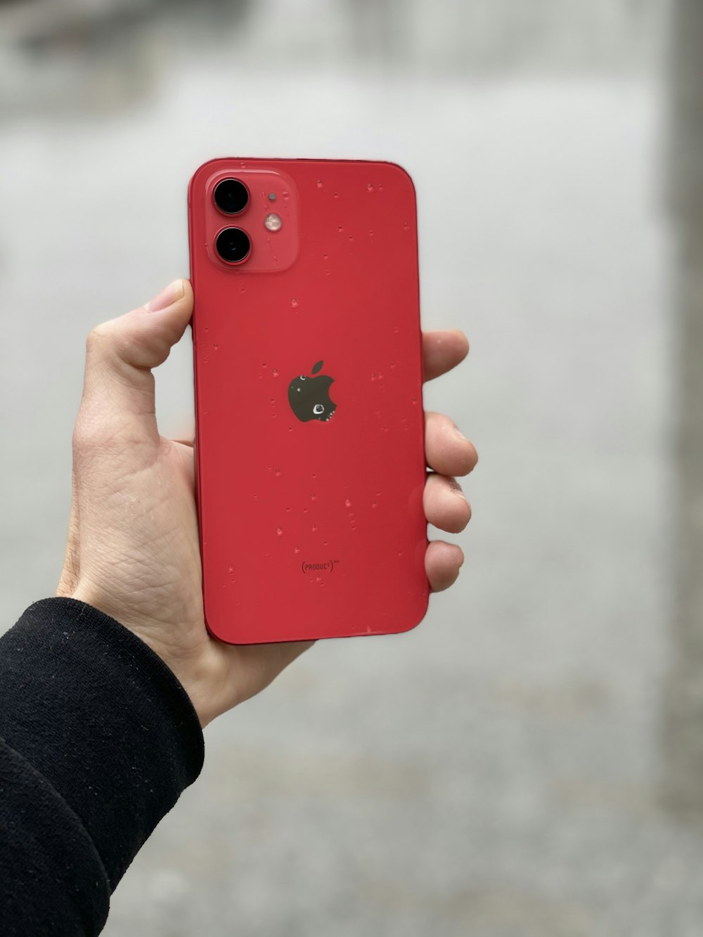 person holding red iphone 7