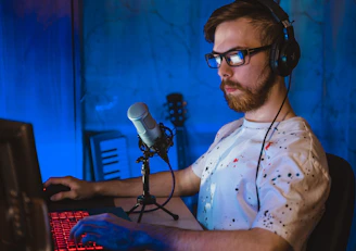 man in white and blue floral button up shirt wearing black framed eyeglasses