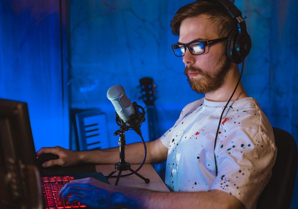 man in white and blue floral button up shirt wearing black framed eyeglasses