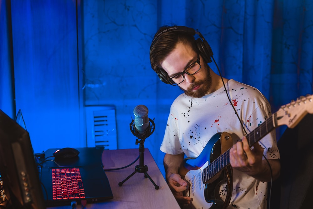 man in white crew neck t-shirt playing electric guitar