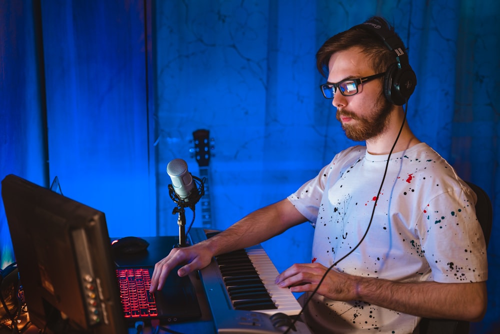 man in blue and white polka dot button up shirt playing electric keyboard