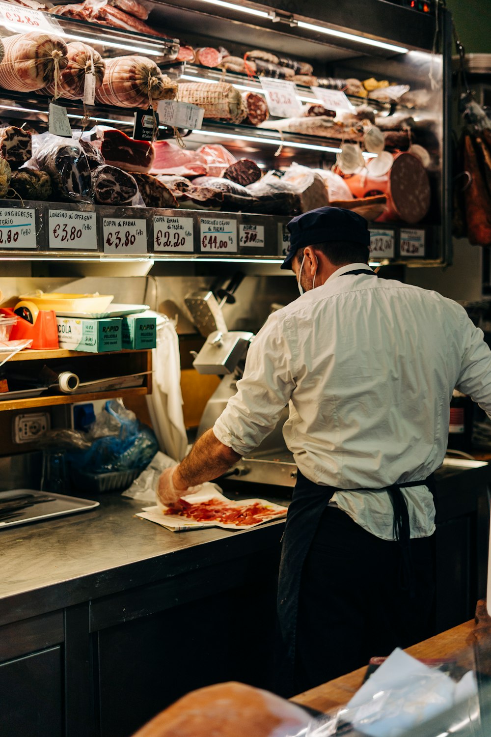 man in white dress shirt standing in front of raw meat