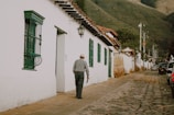 Inna walking along a cobblestone street in a quaint European village.
