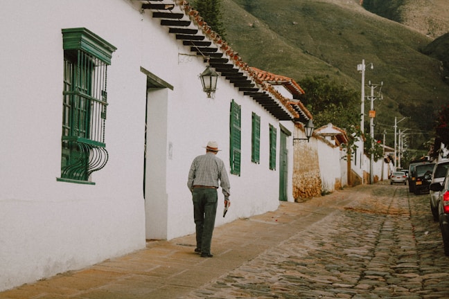Inna walking along a cobblestone street in a quaint European village.