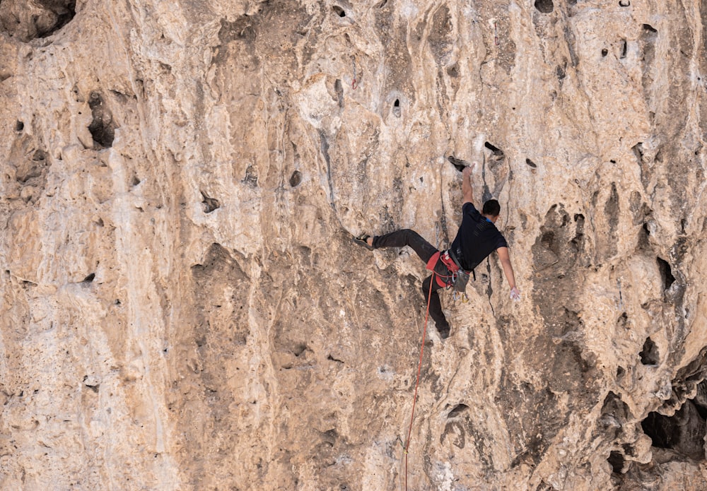 2 Personen klettern tagsüber auf braune Felsformationen