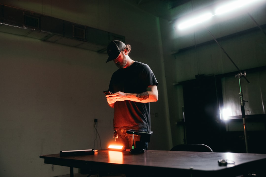 man in black crew neck t-shirt and black cap standing on stage