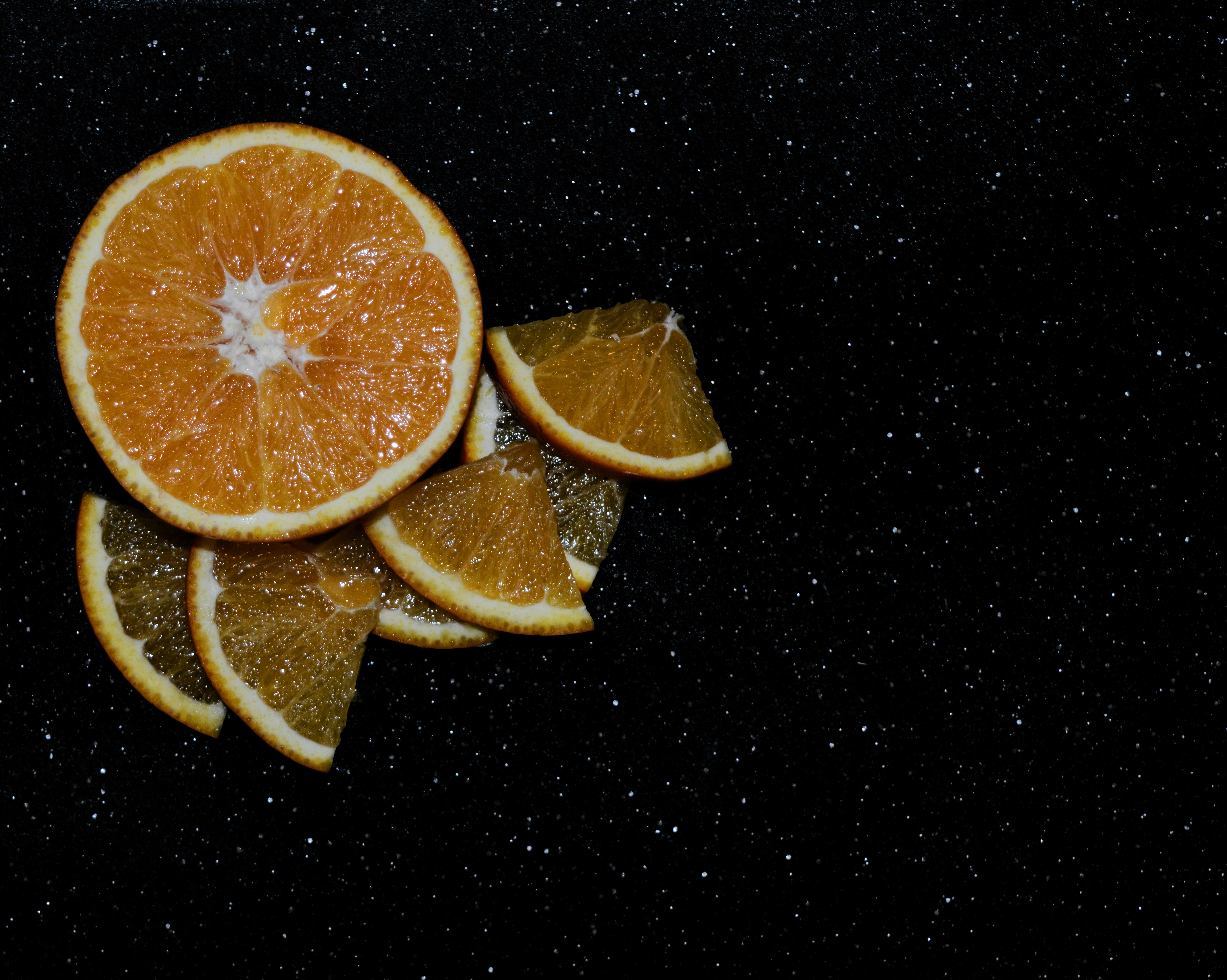 sliced orange fruit on black surface