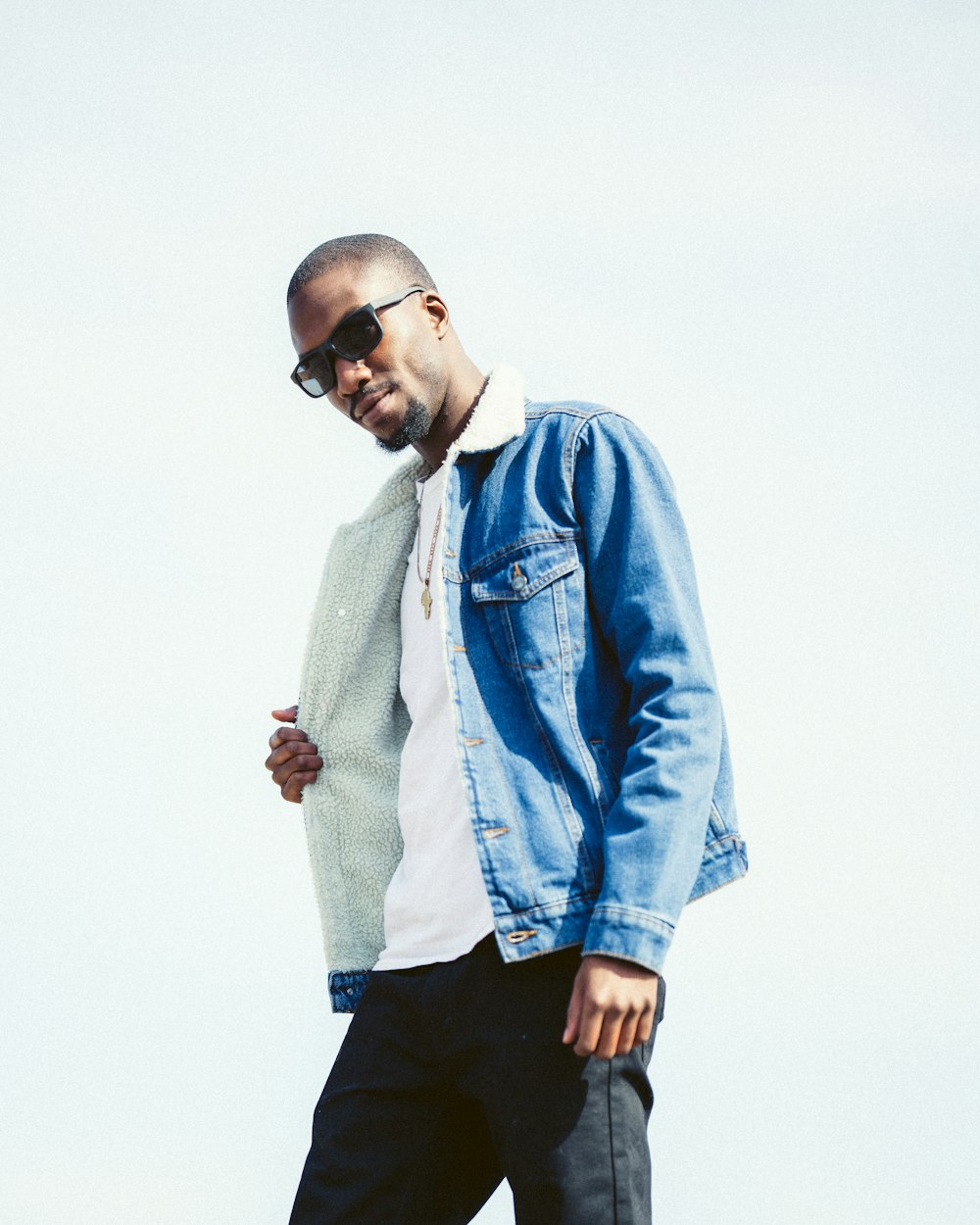 man in blue denim jacket wearing black sunglasses