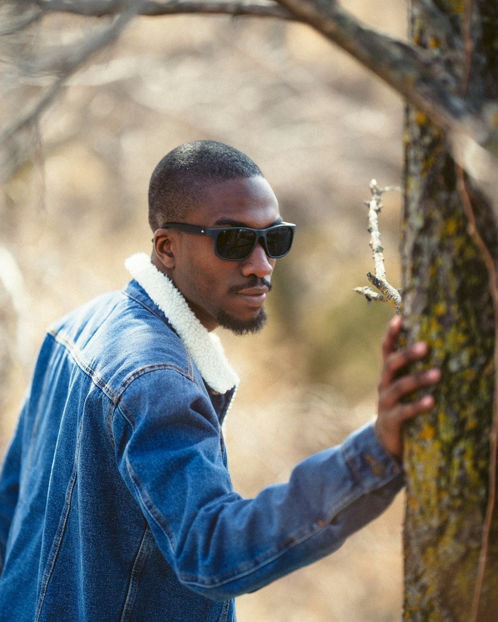 man in blue denim jacket wearing black sunglasses