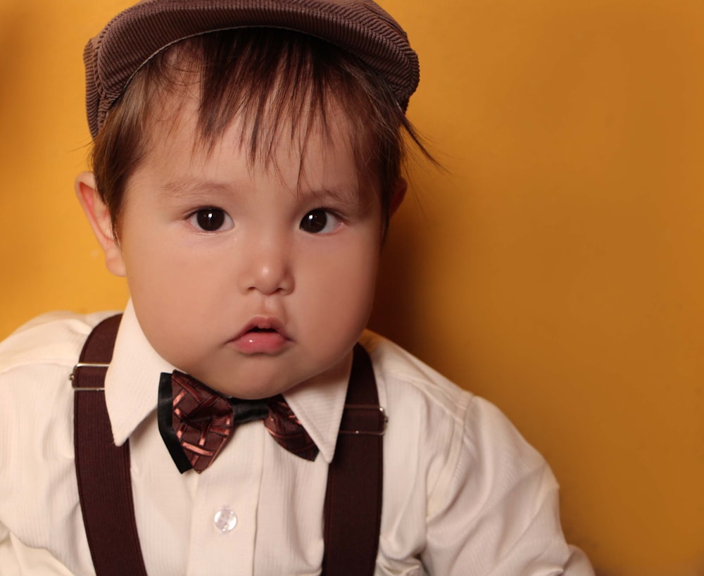 boy in white dress shirt wearing brown hat