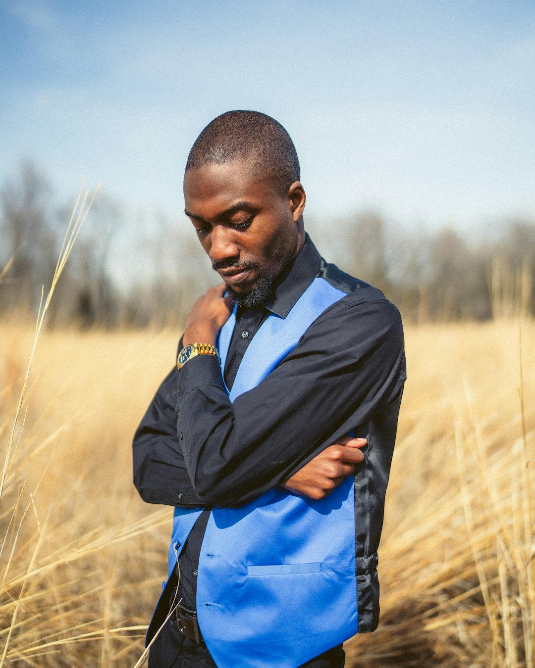 man in black jacket standing on brown grass field during daytime