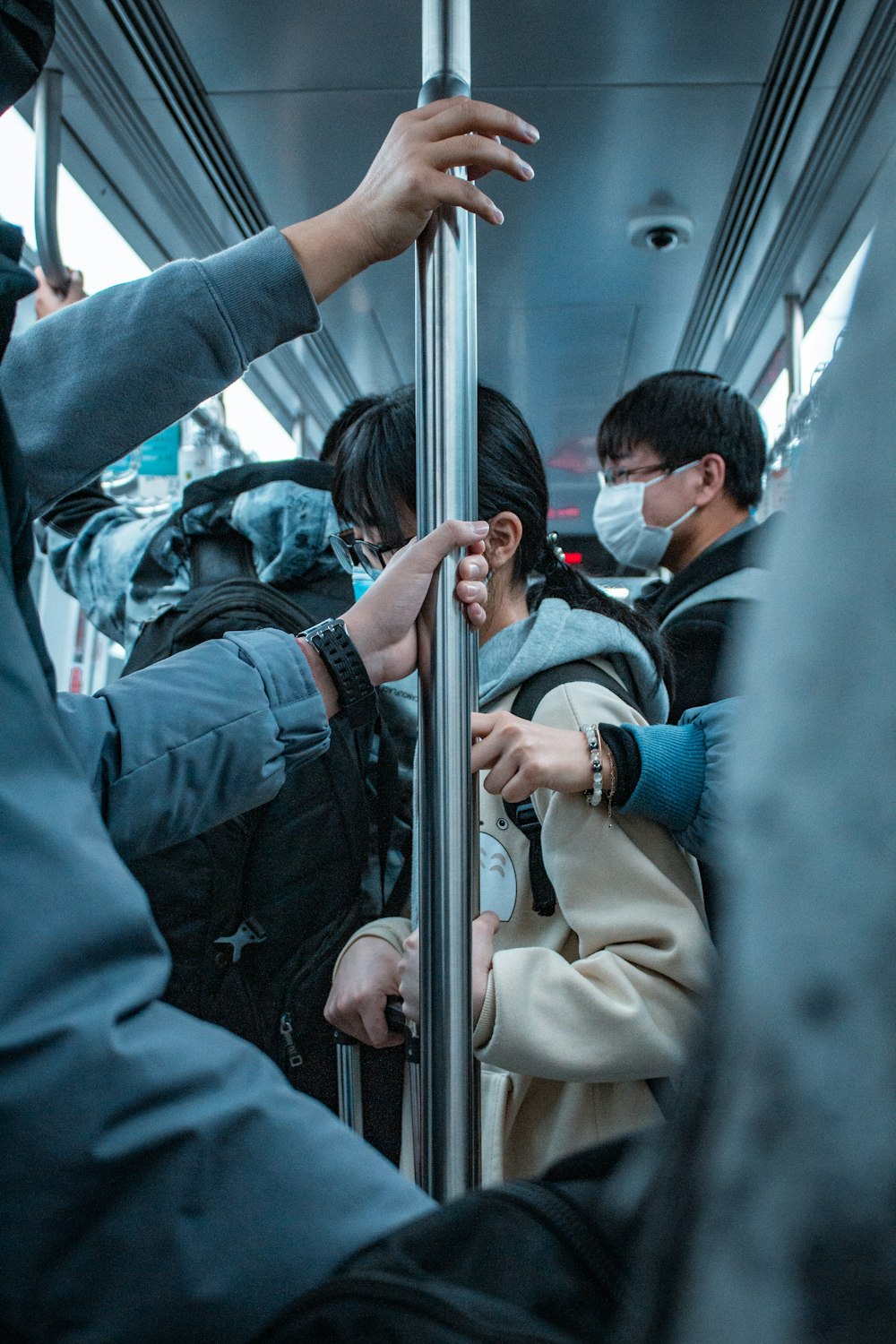 man in brown coat sitting on bus seat