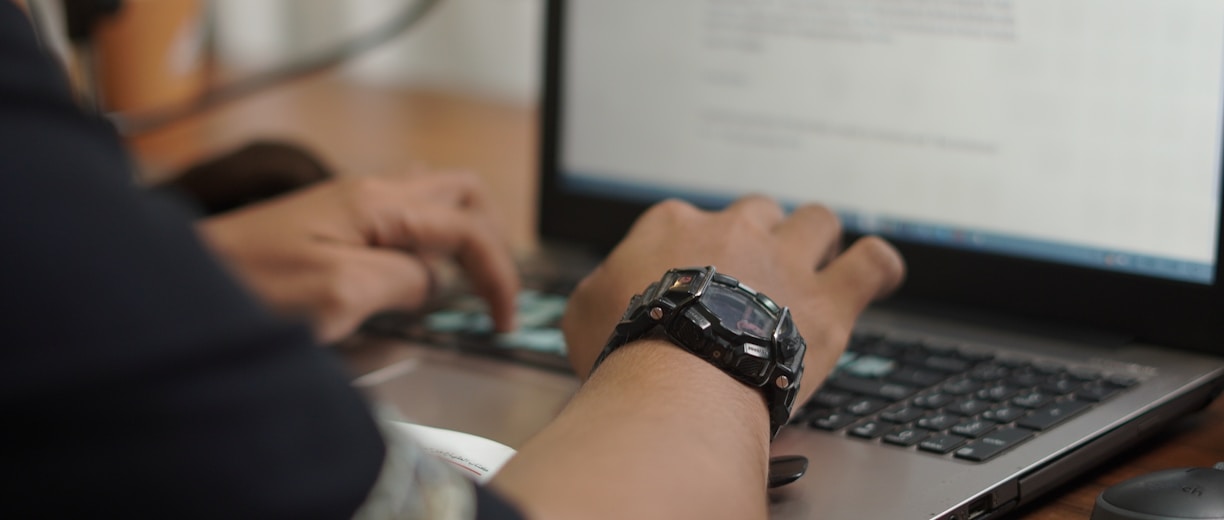 person wearing black and silver watch holding computer mouse