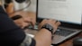person wearing black and silver watch holding computer mouse