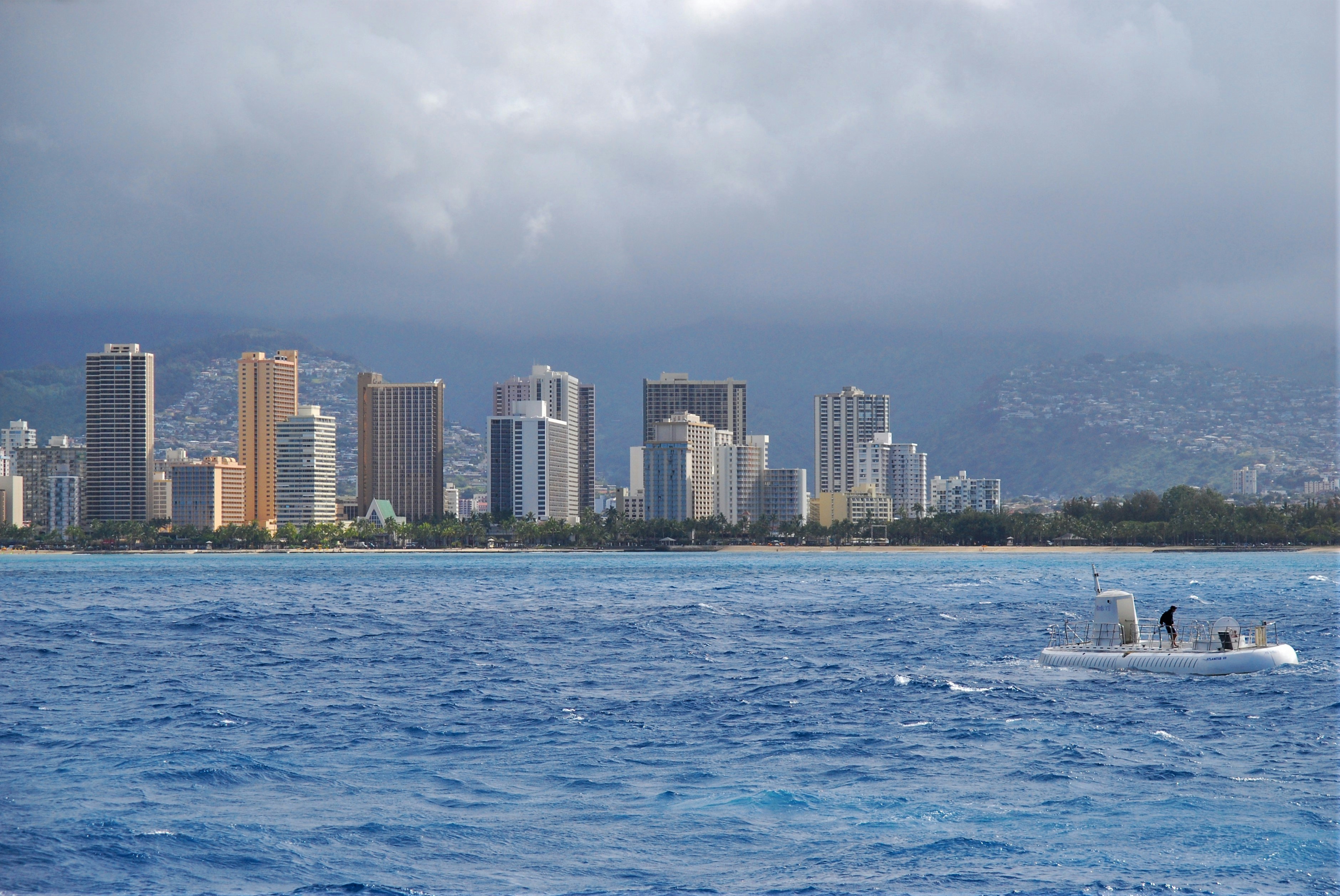 city skyline across body of water under cloudy sky during daytime