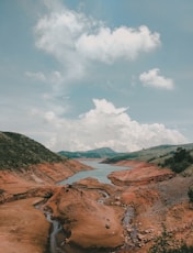 brown and green mountains under white clouds and blue sky during daytime