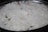 A large serving dish filled with white basmati rice, with a few visible pieces of vegetables such as small green and orange fragments indicating the presence of spices or herbs.