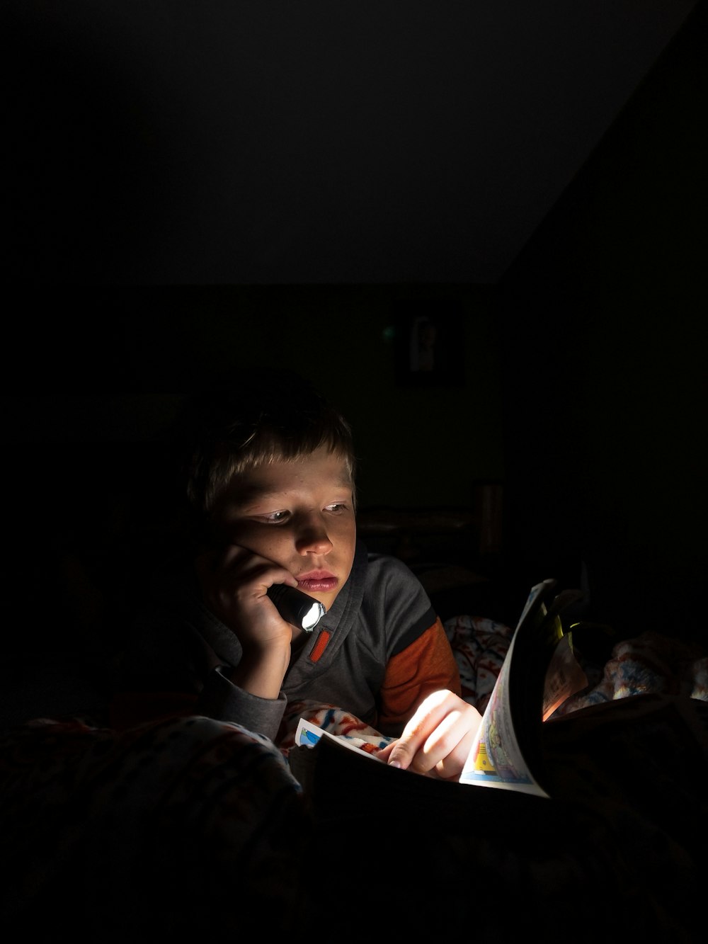 boy in black and white long sleeve shirt holding book