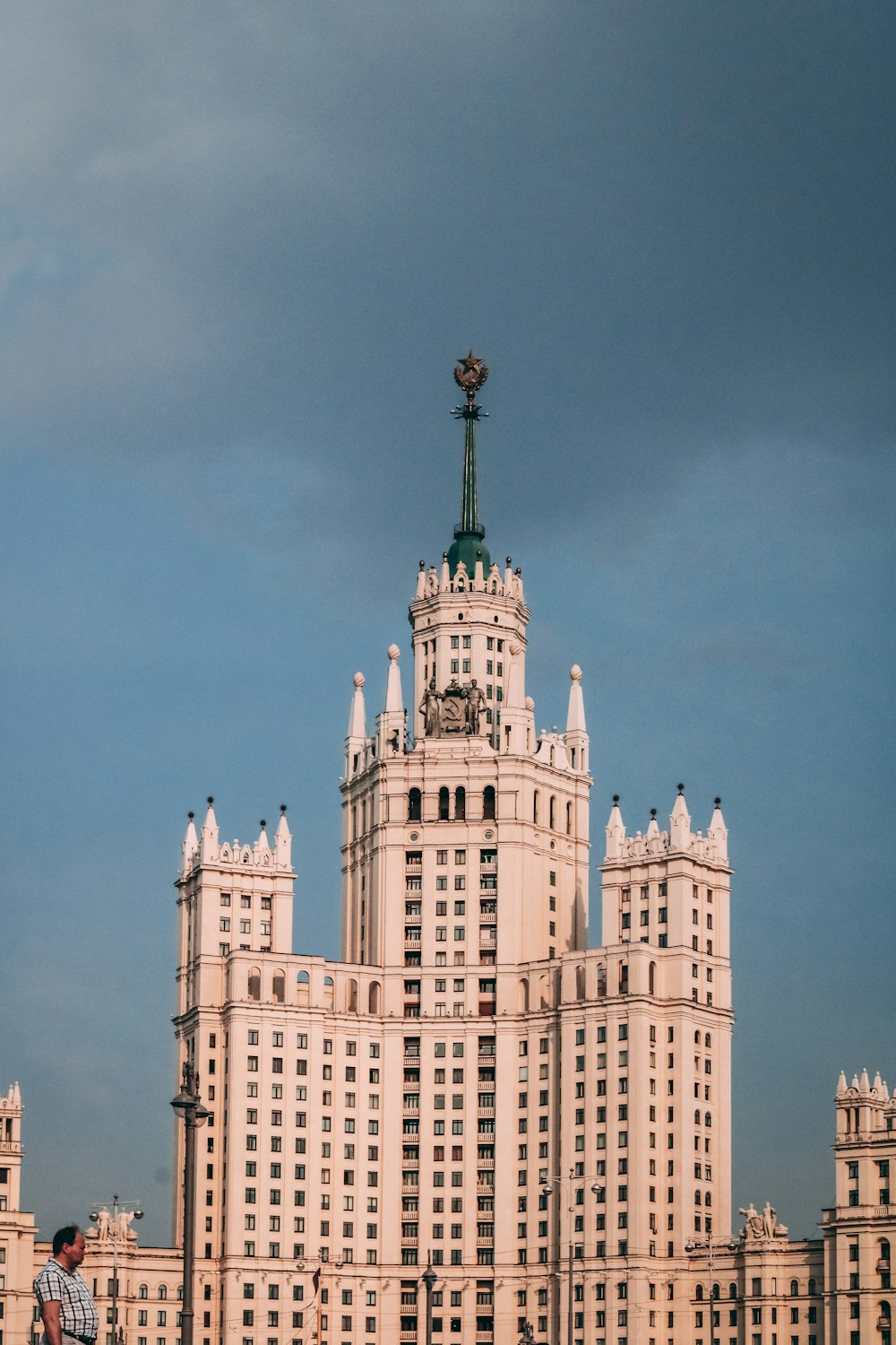 Edificio de hormigón blanco y verde bajo el cielo azul durante el día