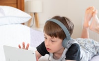 girl in gray t-shirt using white laptop computer