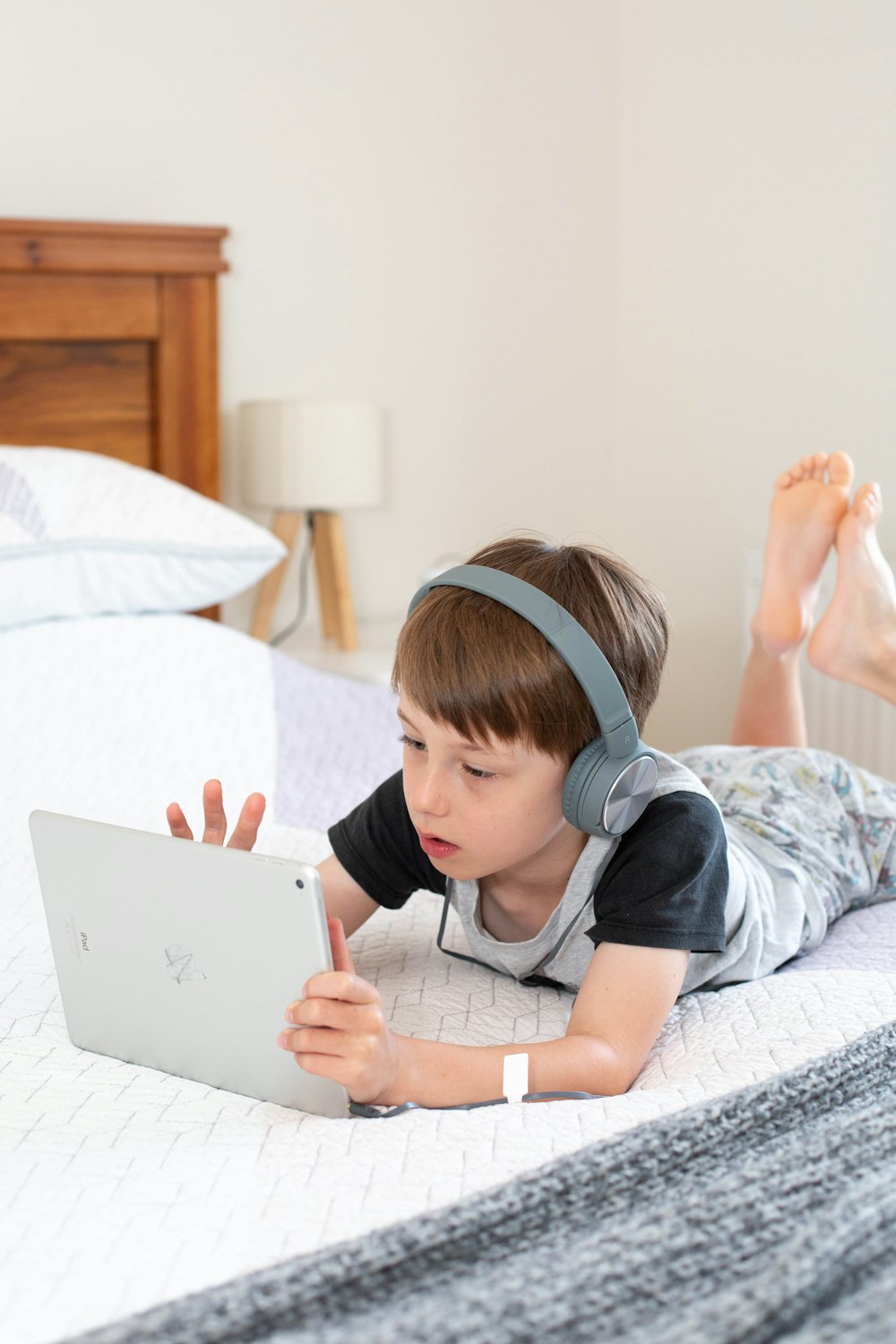 Ragazza in maglietta grigia usando il computer portatile bianco