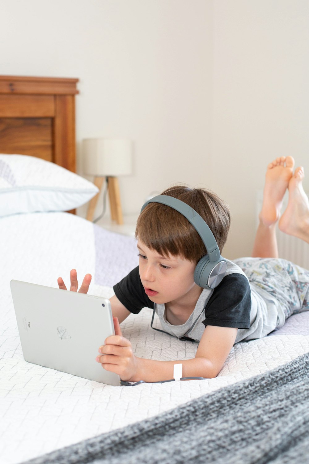Chica en camiseta gris usando computadora portátil blanca