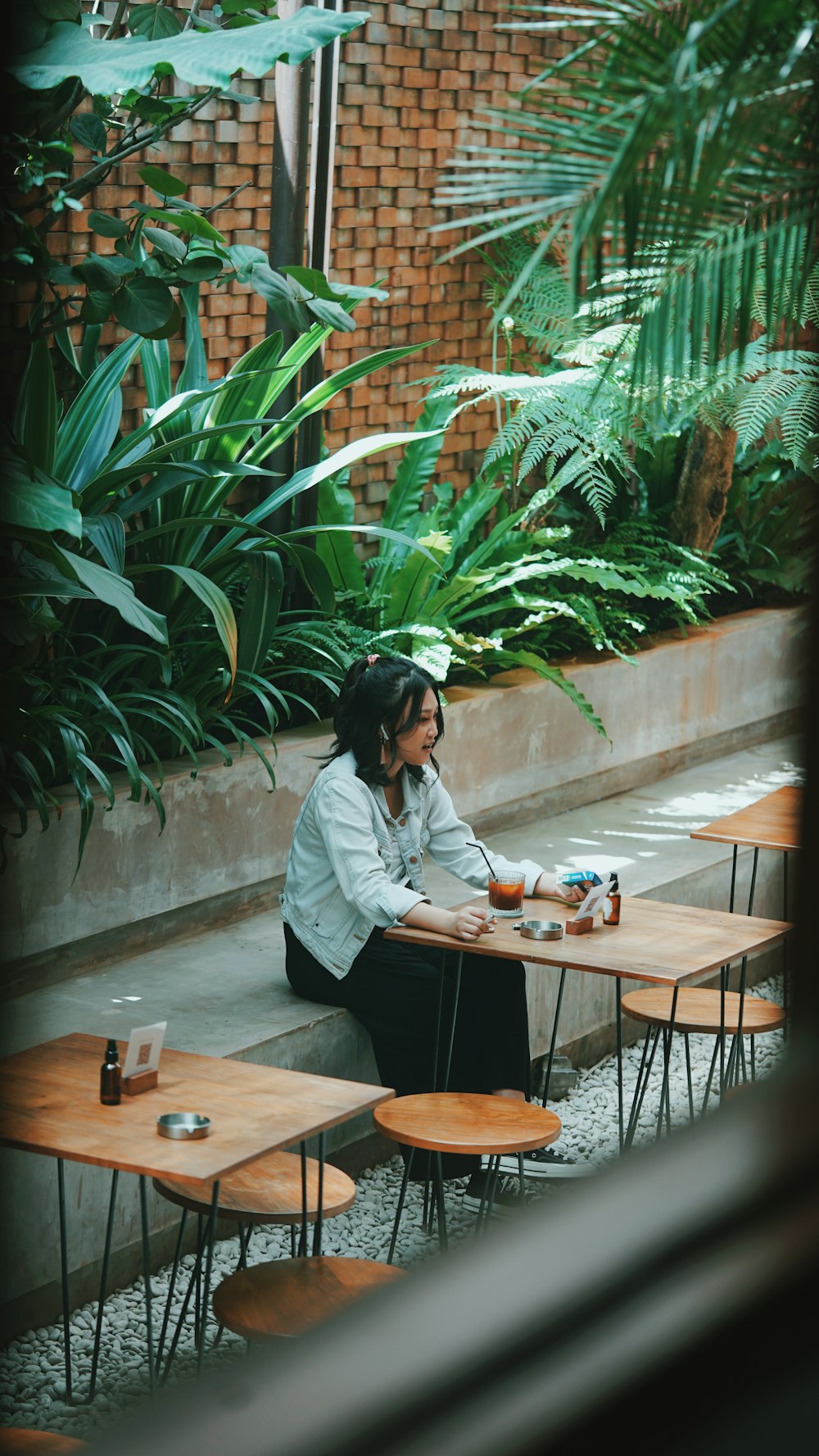 woman in white long sleeve shirt sitting on brown wooden chair