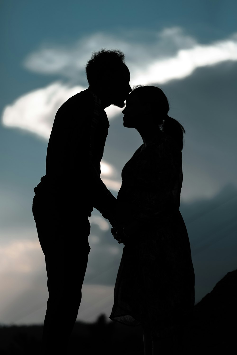 silhouette of couple kissing during daytime