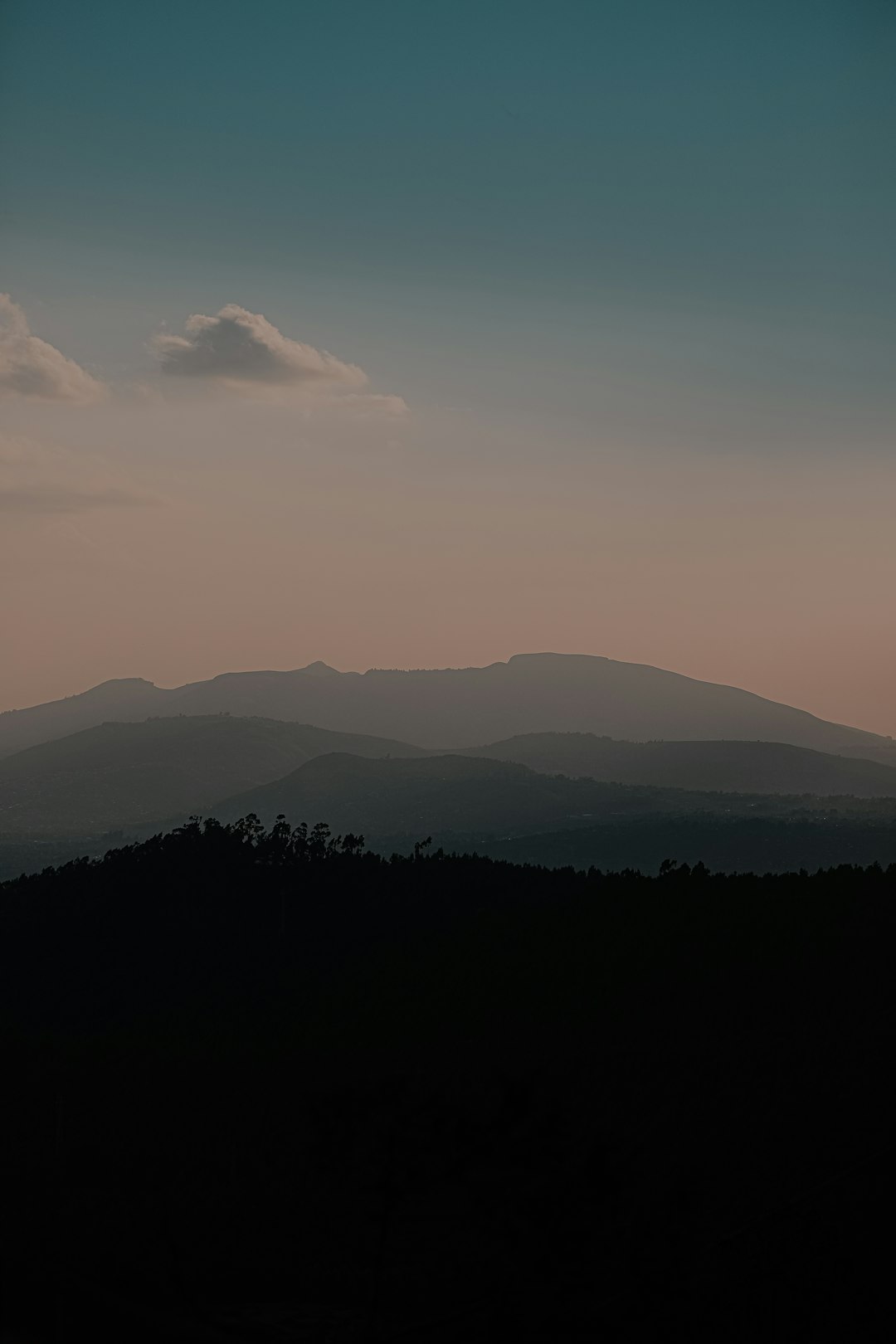 silhouette of mountains under white clouds during daytime