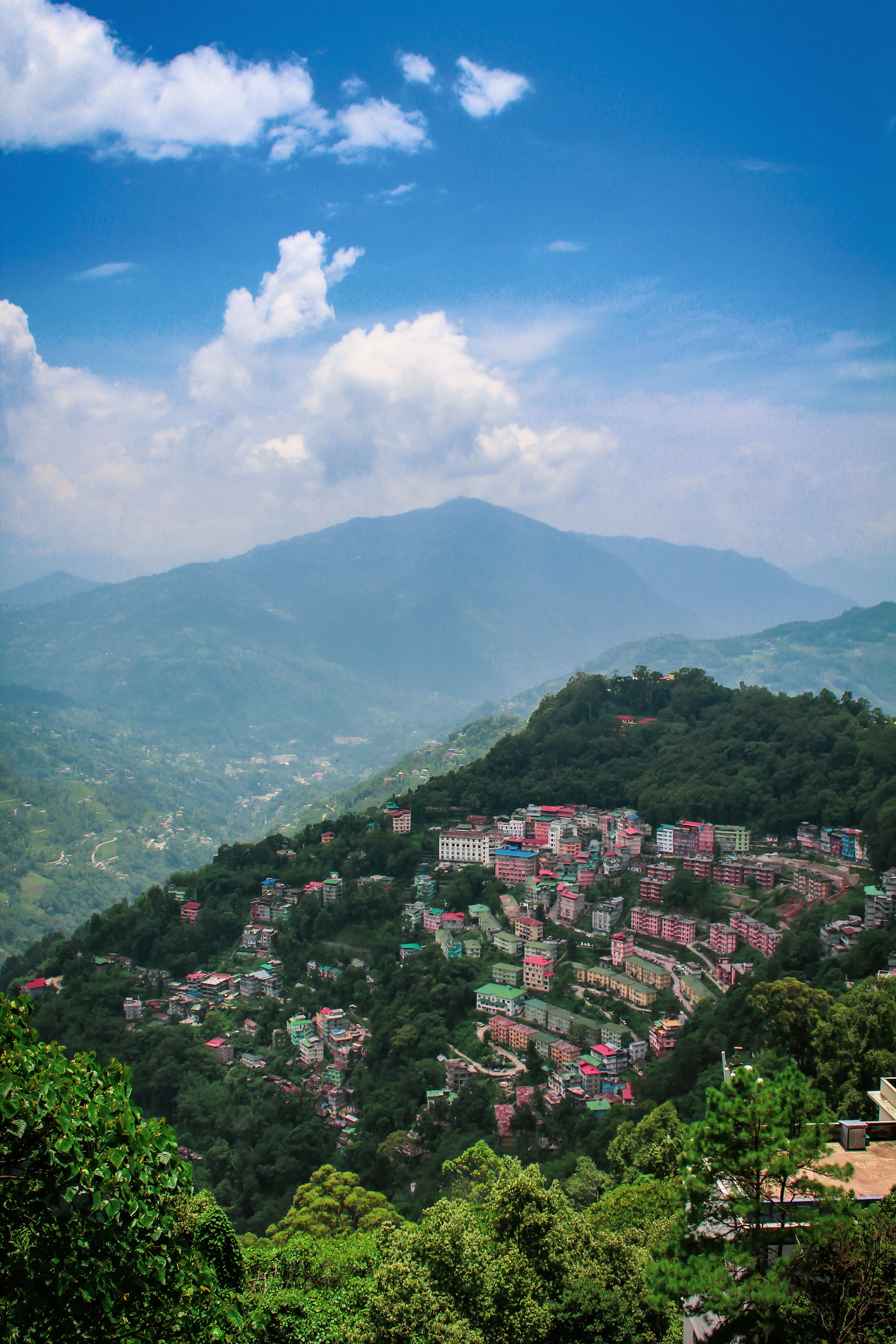 Hillside houses stacked on a Sikkim mountain under a blue sky